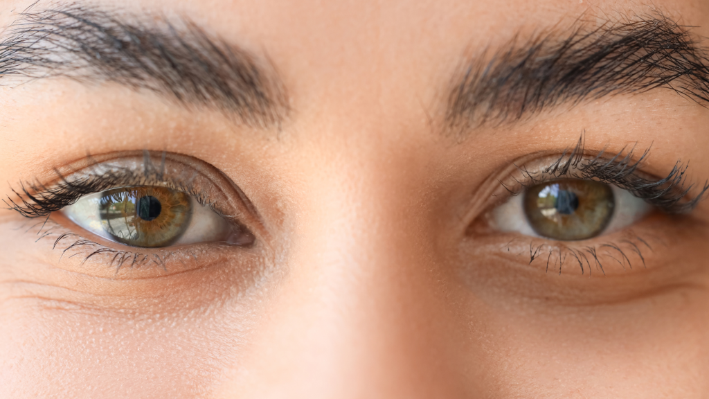 Close-up of a person's eyes with green irises and dark eyelashes