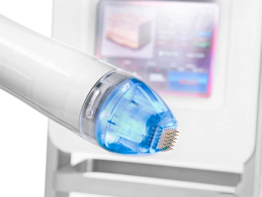 Device with a blue tip and needles, positioned in front of a digital display