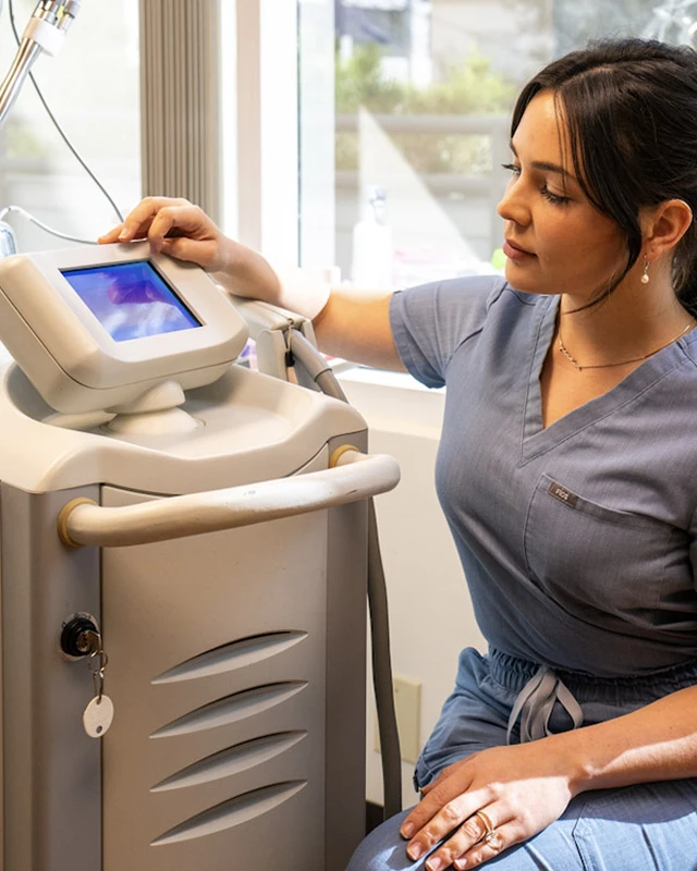 a woman in a medical scrubs looking at a device