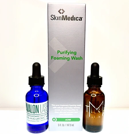 Two bottles of liquid next to a rectangular box labeled "Purifying Foaming Wash."