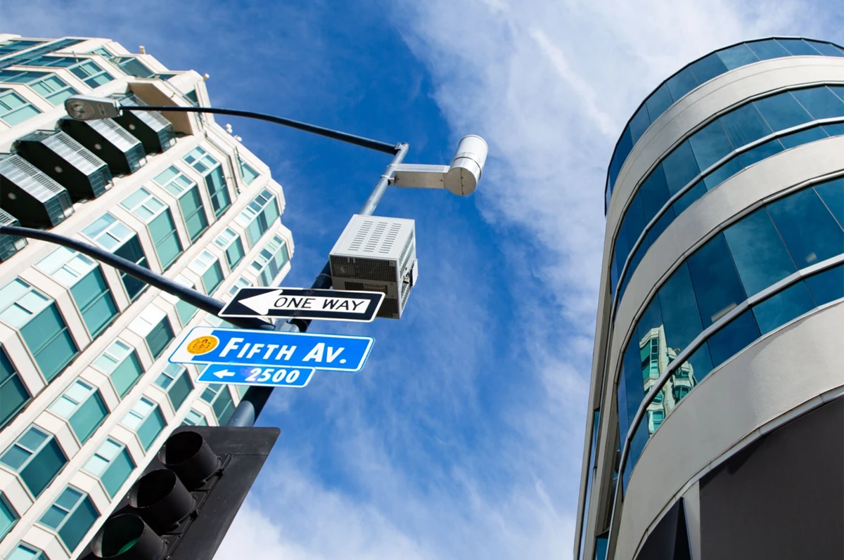 Intersection with street signs, buildings, and a blue sky
